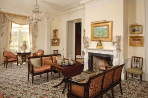 View of the parlor, with the Houdon bust of Robert Fulton in the alcove. Childe Hassam’s (1859–1935) Spring Landscape, 1906, hangs above the carved mantel, in front of which is a Baltimore Classical drop-leaf table. On the left wall, above the New York side chair, hangs Venice by Rhoda Holmes Nicholls (1854–1930), below which is John Singer Sargent’s (1856–1925) Corfu of 1909. John Twachtman’s (1853-1902) Harbor Scene and Sargent’s Interior of the Basilica de San Marco, Venice, are highlighted over the Federal side chair to the right of the mantel.