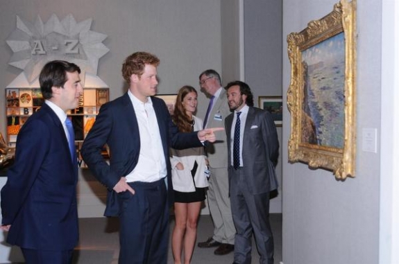 Wenty Beaumont, on left, a director of Dickinson, discusses Monet&#039;s Étude de mur vue des bauteurs (1881) with Prince Harry. The painting has a guide price of approximately £5 million.