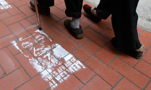 People in Hong Kong walk past street stencils of detained Chinese artist and activist Ai Weiwei. The words &#039;Who&#039;s afraid of Ai Weiwei&#039; are painted underneath. 