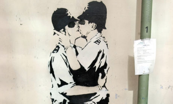 Banksy&#039;s graffiti piece depicting two policemen kissing. It is to be sold to an American gallery.