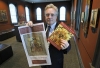Kent Russell, curator at the Museum of Russian Icons, in Clinton, Mass., displays a newspaper advertisement (left) and a catalog for a canceled exhibition. The icons, lent by the Andrey Rublev Museum in Moscow, was prematurely closed and the objects sent back to Russia after artifacts across the country were embargoed by Russia.