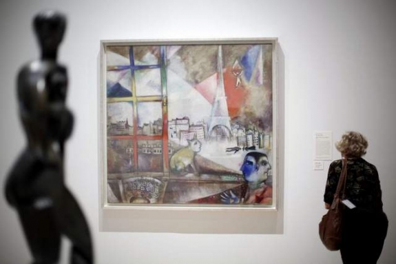A visitor views the exhibit "Paris Through the Window: Marc Chagall and His Circle," including Chagall's painting, "Paris Through the Window," at the Philadelphia Museum of Modern Art. 