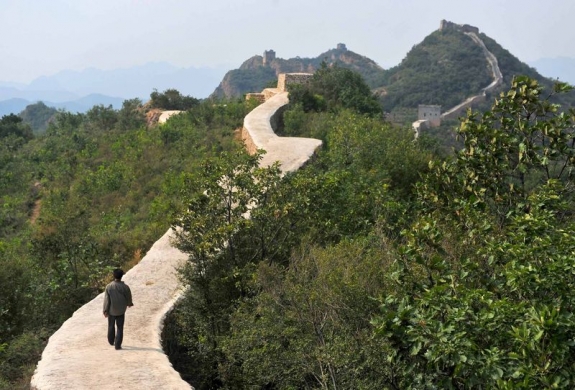 A villager walks across a restored section of the Great Wall in Suizhong County in northeastern China's Liaoning Province, on Wednesday, Sept. 21, 2016.