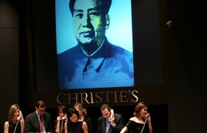 Christie&#039;s employees taking bids in 2006 for Warhol&#039;s &quot;Mao.&quot; The portrait was sold to Joseph Lau, a real estate billionaire.